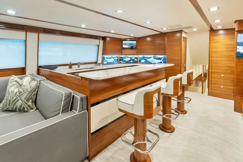 Slide: The Image of Luxurious interior of 2023 Viking 80 Convertible yacht with modern bar and seating area. - 14