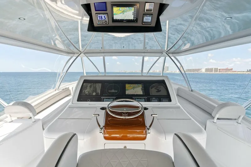 Slide: The Image of 2023 Viking 80 Convertible yacht helm with advanced navigation displays, overlooking the ocean. - 2
