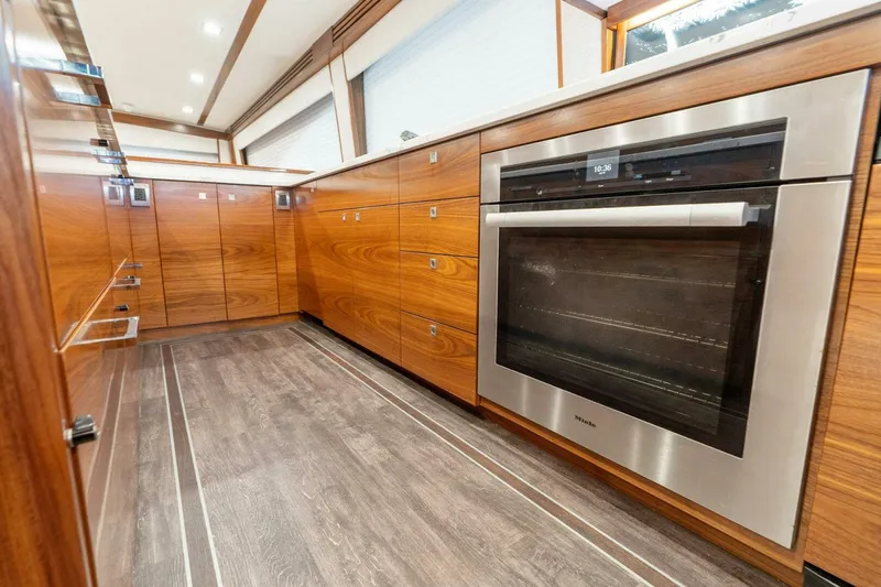 Slide: The Image of Luxurious kitchen interior of 2023 Viking 80 Convertible yacht with wood cabinetry and modern oven. - 20