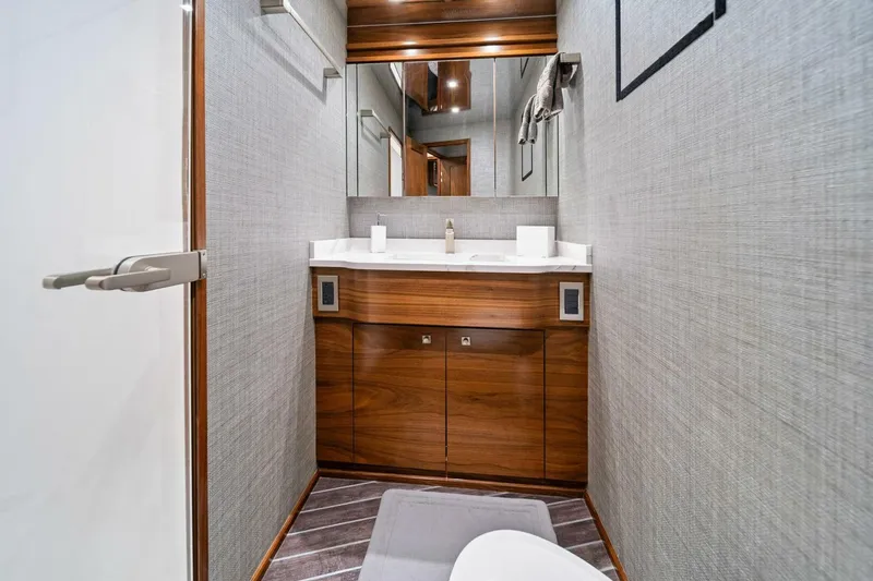 Slide: The Image of Modern bathroom interior in 2023 Viking 80 Convertible yacht, featuring sleek wood cabinetry and elegant fixtures. - 41