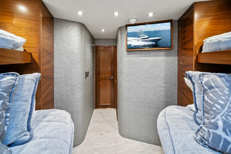 Slide: The Image of 2023 Viking 80 Convertible yacht interior with bunk beds and wall-mounted TV. - 42