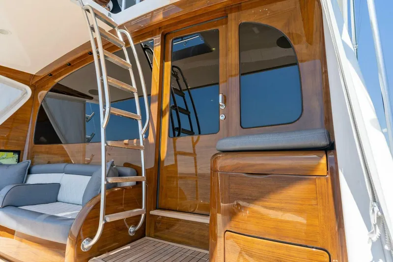 Slide: The Image of 2023 Viking 80 Convertible yacht with polished wood finish and sleek ladder. - 45