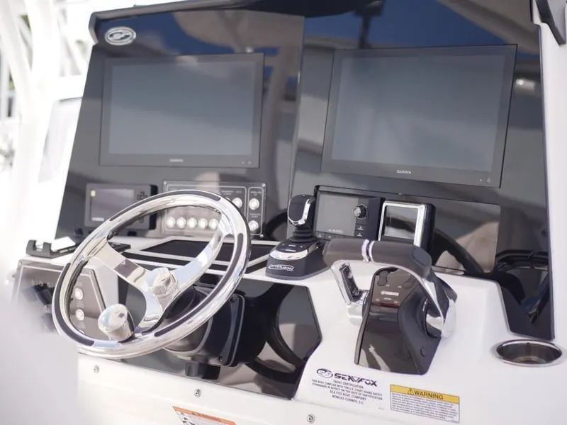 Slide: The Image of Control panel of 2021 Sea Fox 328 Commander boat with dual screens and steering wheel. - 2