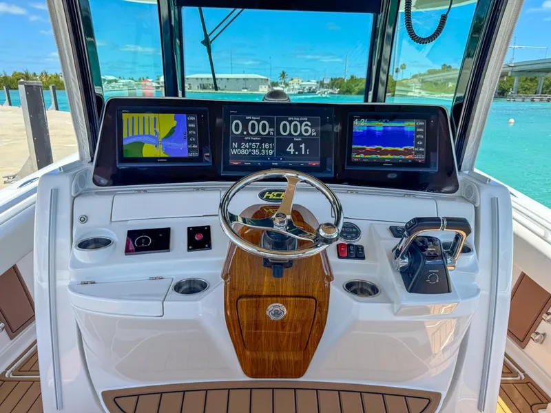 Slide: The Image of 2019 HCB 39 Speciale boat dashboard with navigation screens and steering wheel. - 16