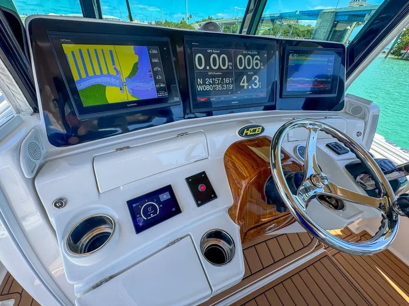 Slide: The Image of 2019 HCB 39 Speciale boat dashboard with navigation screens and steering wheel. - 18
