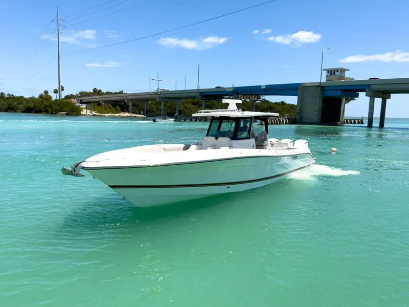 Slide: The Image of 2019 HCB 39 Speciale boat cruising in turquoise waters near a bridge. - 3