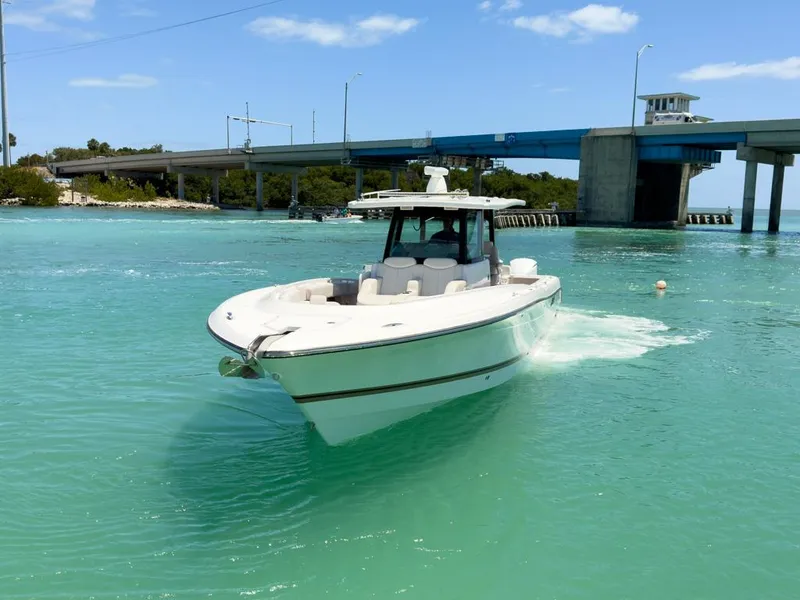 Slide: The Image of 2019 HCB 39 Speciale boat cruising in turquoise waters near a bridge. - 4