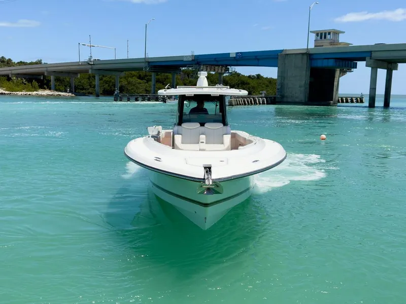 Slide: The Image of 2019 HCB 39 Speciale boat cruising in turquoise waters near a bridge. - 5