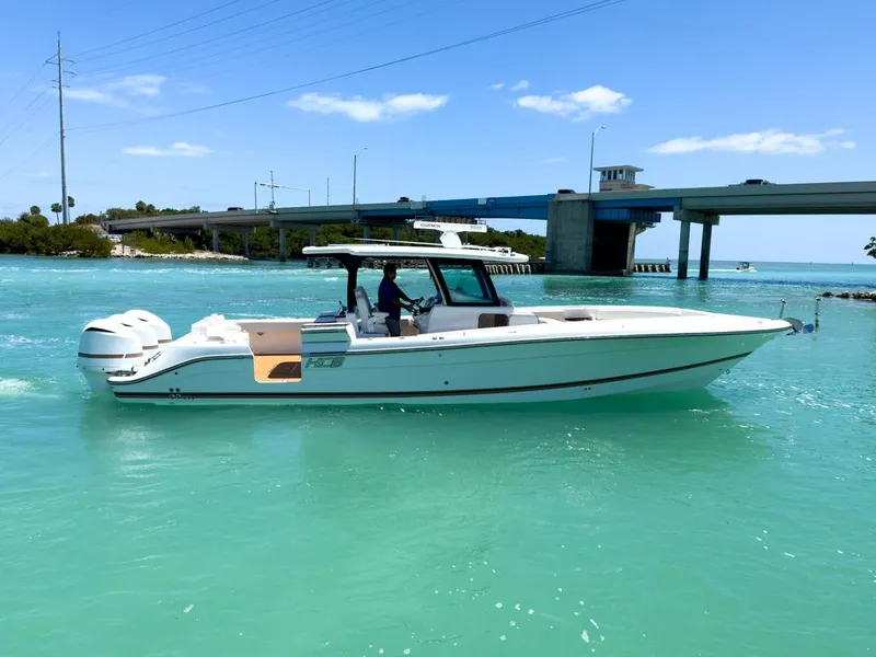 Slide: The Image of 2019 HCB 39 Speciale boat cruising on turquoise water near a bridge. - 6