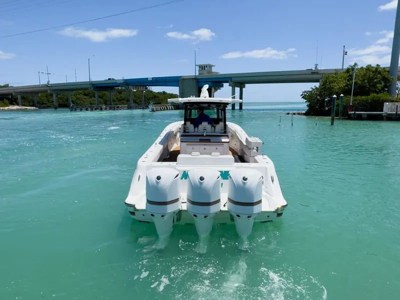 Slide: The Image of 2019 HCB 39 Speciale boat cruising in turquoise waters near a bridge. - 8