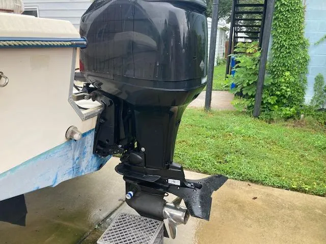 Slide: The Image of KenCraft Challenger 190 boat with outboard motor, 1995 model, parked on concrete near grass. - 5