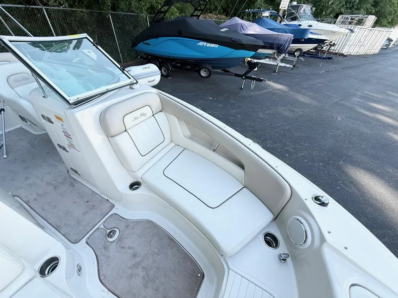 Slide: The Image of 2010 Sea Ray 220 Sundeck interior with white seating and open windshield. - 12