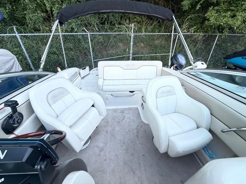 Slide: The Image of Interior of a 2010 Sea Ray 220 Sundeck boat with white seating and steering wheel. - 6