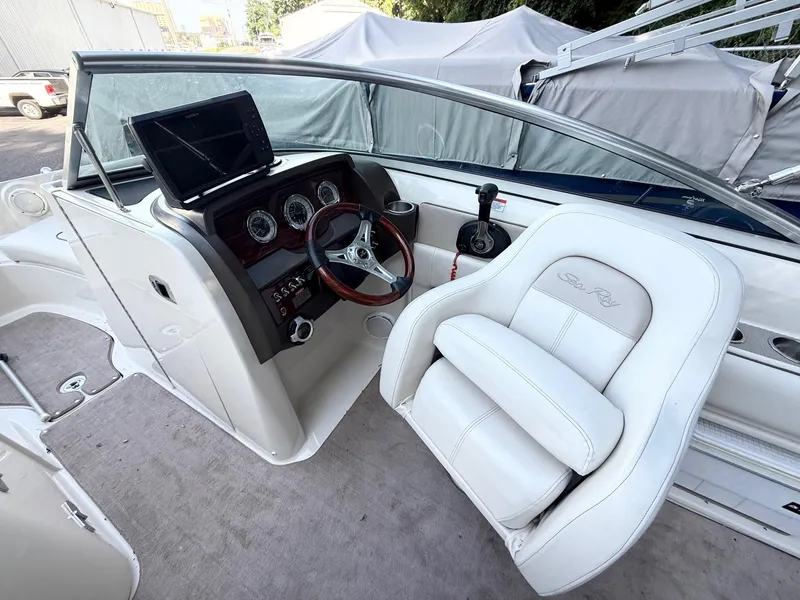 Slide: The Image of 2010 Sea Ray 220 Sundeck cockpit with steering wheel and dashboard controls. - 8