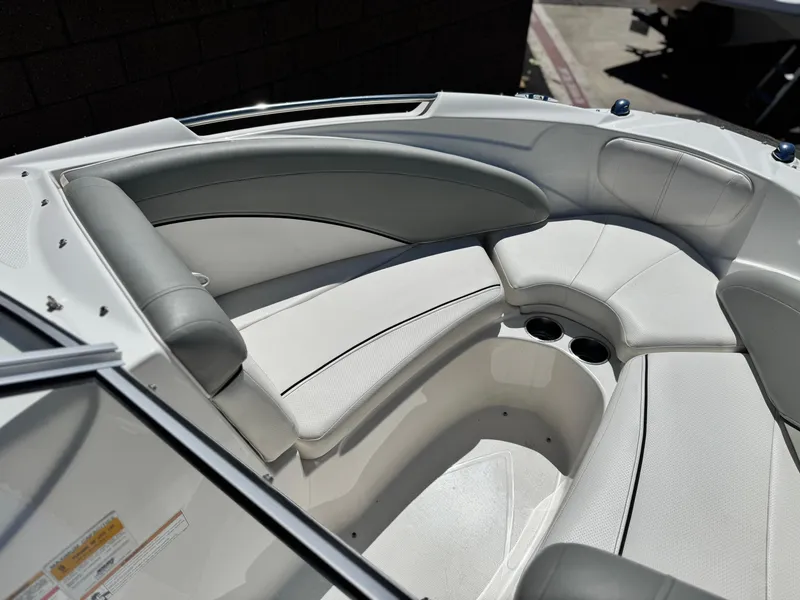 Slide: The Image of 2012 Bayliner 215 boat interior with white and gray seating, cup holders, and sleek design. - 11