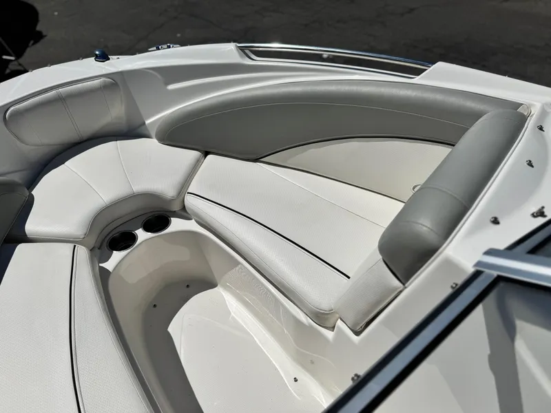 Slide: The Image of 2012 Bayliner 215 boat interior with white and gray seating, cup holders visible. - 12