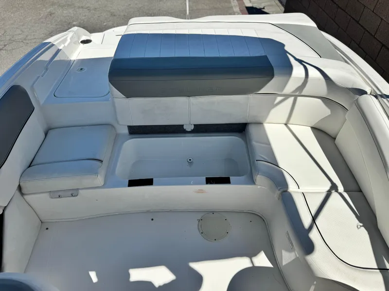 Slide: The Image of 2012 Bayliner 215 boat interior with white seating and storage compartment. - 14