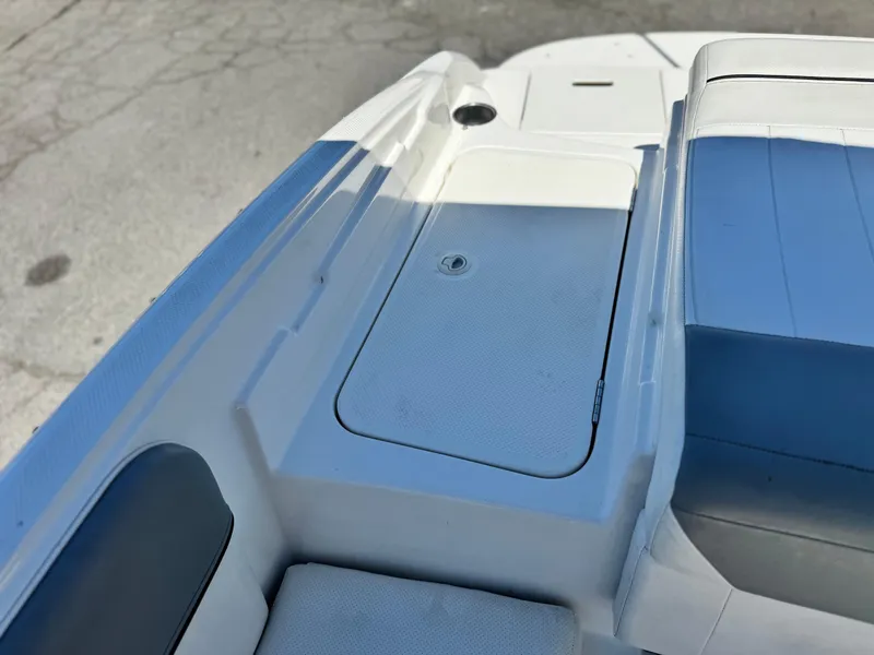 Slide: The Image of 2012 Bayliner 215 boat interior with storage compartment and seating. - 15
