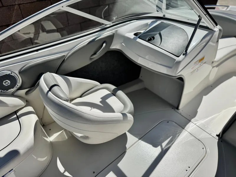 Slide: The Image of 2012 Bayliner 215 boat interior with white seating and dashboard. - 19