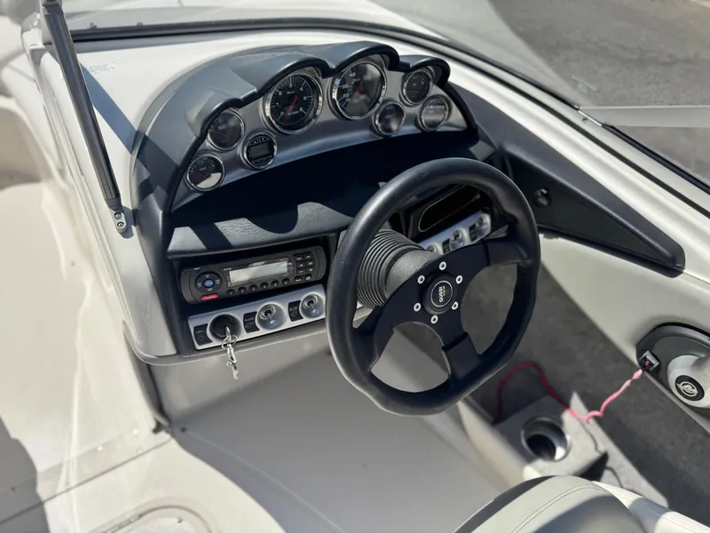 Slide: The Image of 2012 Bayliner 215 boat dashboard with steering wheel and instrument panel. - 22