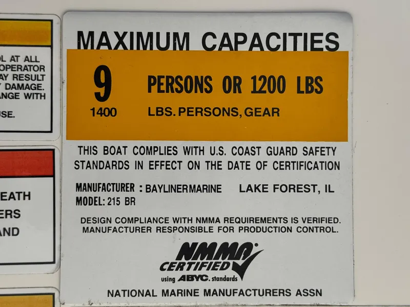 Slide: The Image of Bayliner 215 boat capacity label, 9 persons or 1200 lbs, NMMA certified. - 24