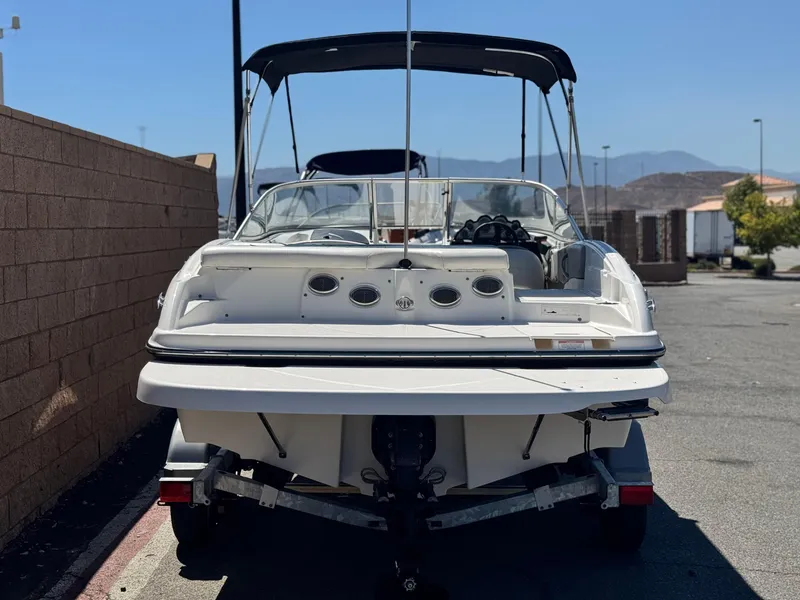 Slide: The Image of 2012 Bayliner 215 boat on trailer, parked outdoors, rear view. - 4
