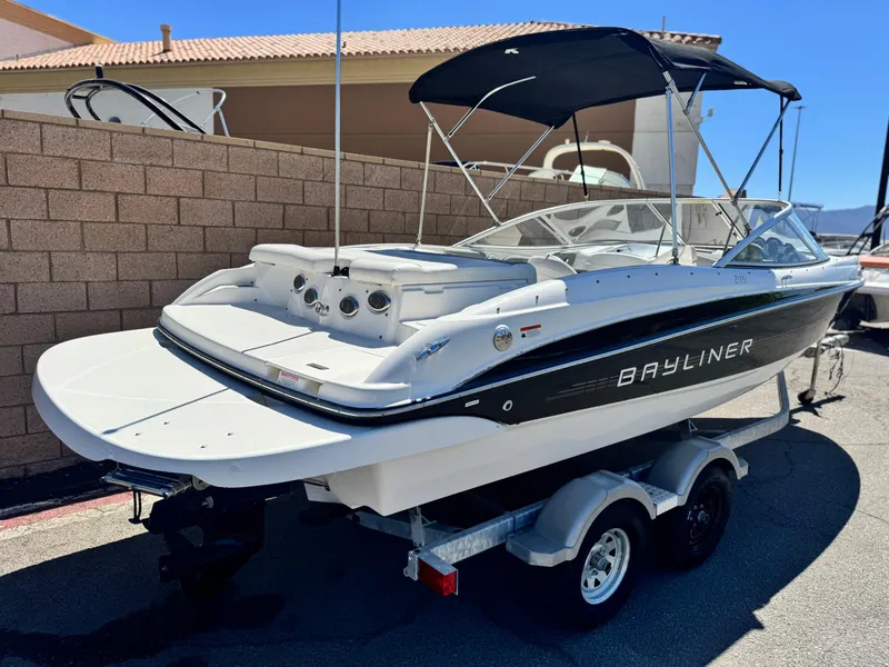 Slide: The Image of 2012 Bayliner 215 boat on trailer, black and white design, parked outdoors. - 5