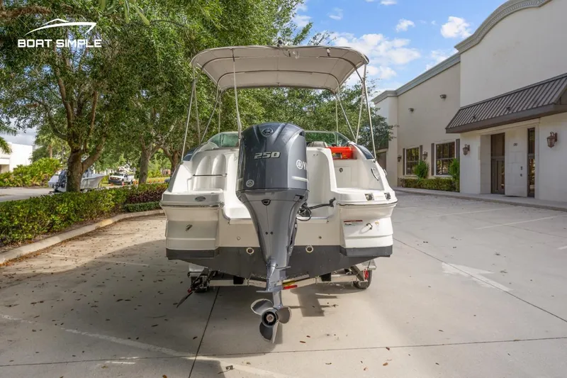Slide: The Image of 2025 Hurricane SunDeck 2400 OB boat with outboard motor, parked outdoors. - 5