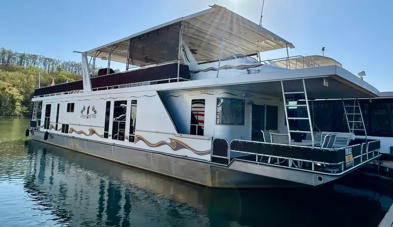 The Image of 2004 Horizon houseboat docked on calm water, featuring spacious deck and upper canopy. - 0