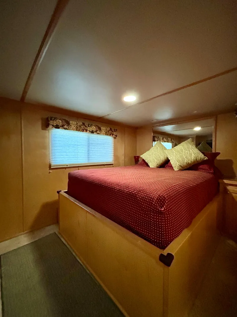 Slide: The Image of Cozy bedroom interior of 2004 Horizon houseboat with red bedding and soft lighting. - 13