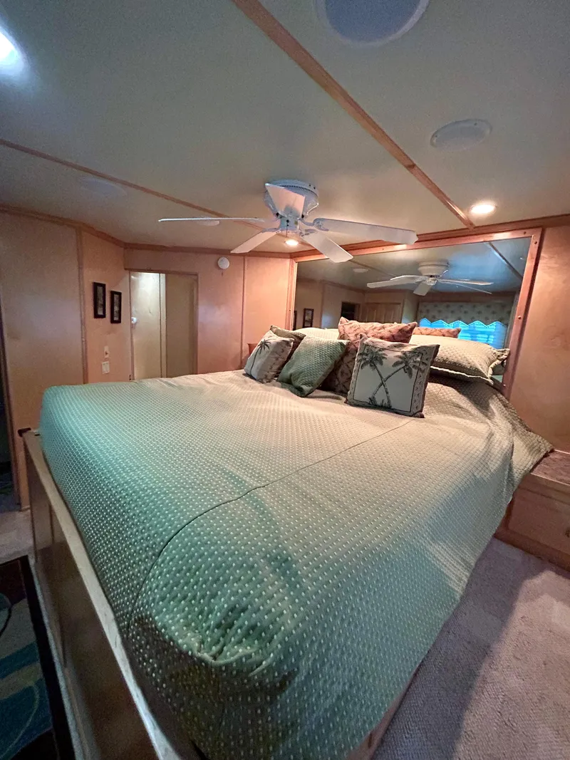 Slide: The Image of Luxurious bedroom interior in a 2004 Horizon houseboat with elegant bedding and ceiling fan. - 18