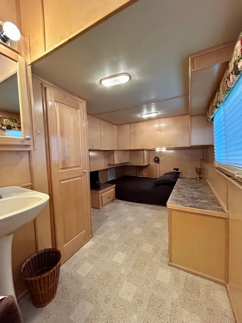 Slide: The Image of Interior of a 2004 Horizon houseboat with wooden cabinetry and a cozy sleeping area. - 19