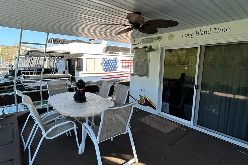 Slide: The Image of 2004 Horizon houseboat deck with table, chairs, and "Long Island Time" sign. - 2