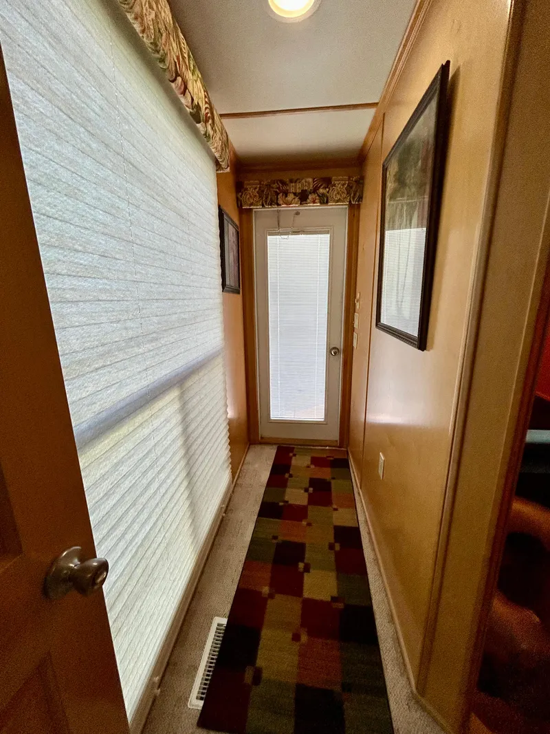 Slide: The Image of Narrow hallway in a 2004 Horizon houseboat with colorful rug and framed artwork. - 20