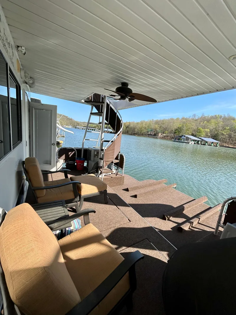 Slide: The Image of 2004 Horizon houseboat deck with seating, overlooking serene lake and wooded shoreline. - 23