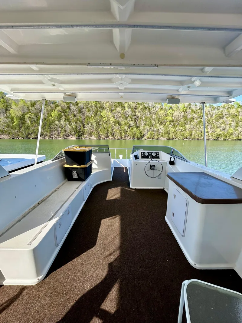 Slide: The Image of 2004 Horizon houseboat interior with seating, steering wheel, and scenic lake view. - 27