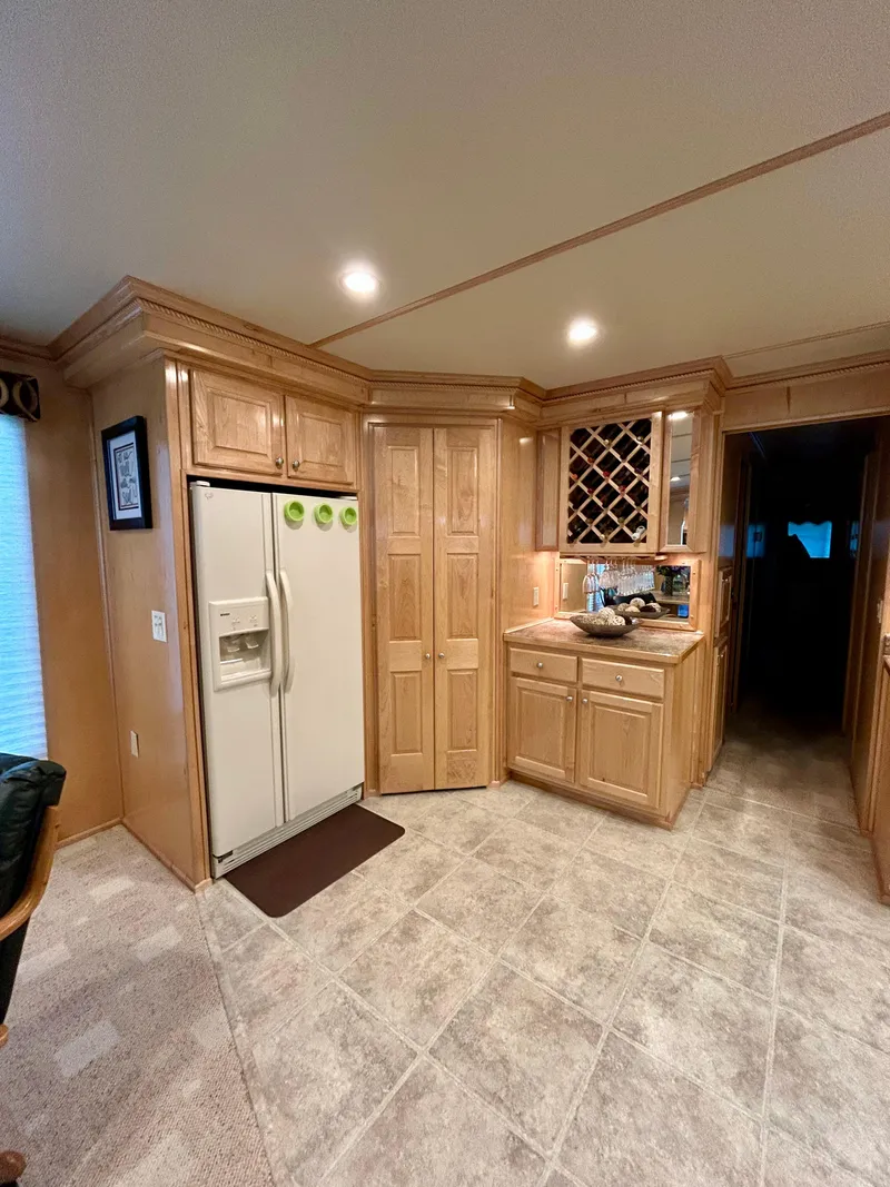 Slide: The Image of Interior of a 2004 Horizon houseboat kitchen with wooden cabinets and a refrigerator. - 9