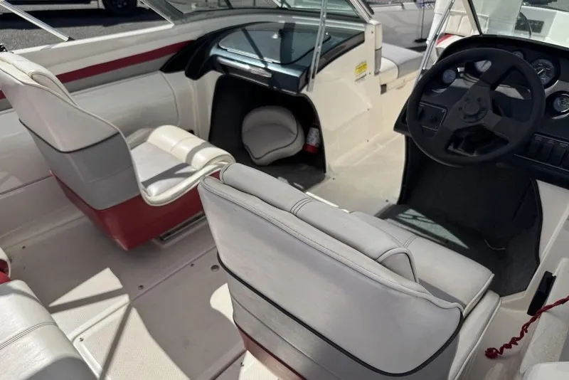 Slide: The Image of 1997 Bayliner Quantum 190 XFS boat interior with white and red seating, steering wheel, and dashboard. - 16