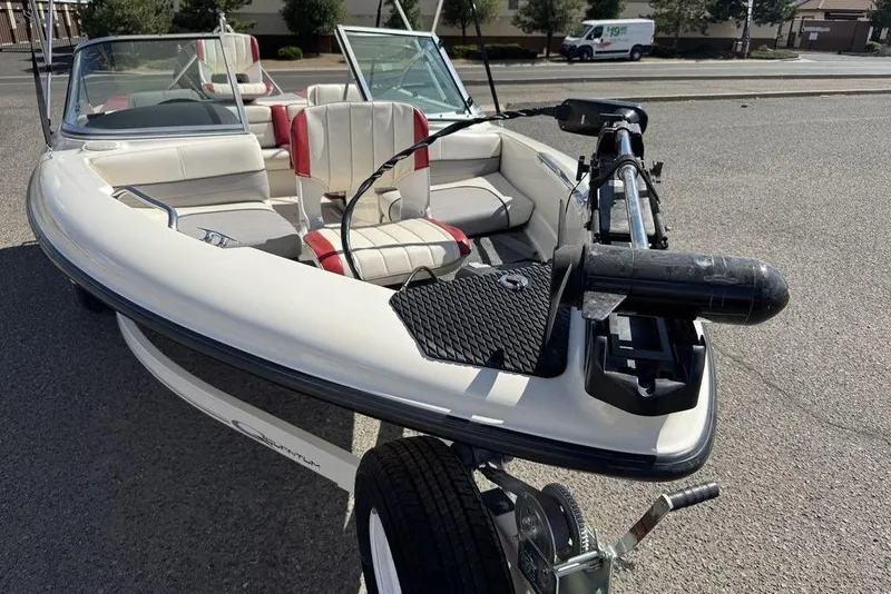 Slide: The Image of 1997 Bayliner Quantum 190 XFS boat with red and white seating, parked on a trailer. - 19