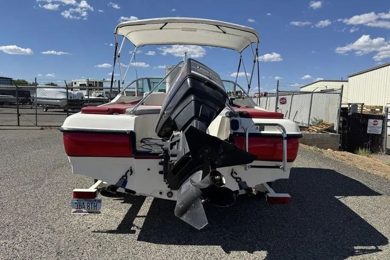 Slide: The Image of 1997 Bayliner Quantum 190 XFS boat with outboard motor, parked outdoors under clear sky. - 23
