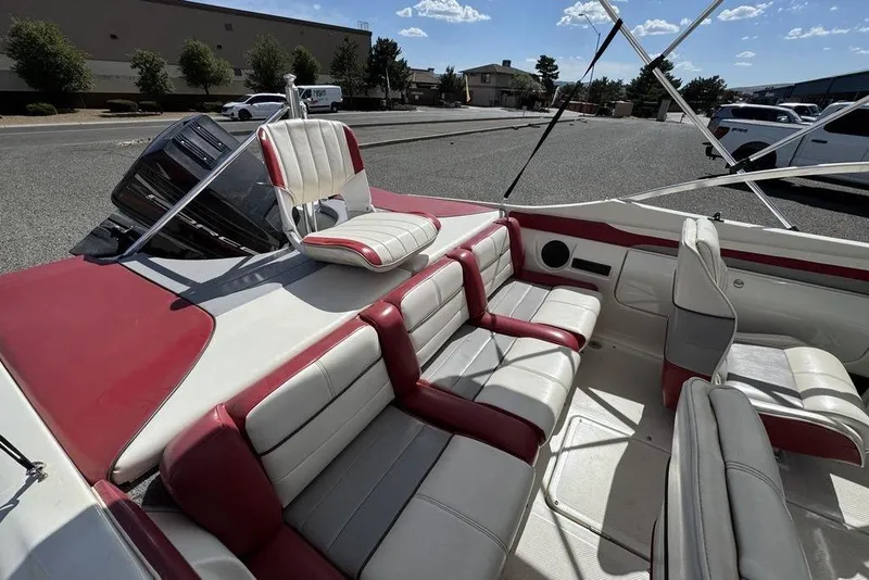 Slide: The Image of 1997 Bayliner Quantum 190 XFS boat interior with red and white seating, parked outdoors. - 28