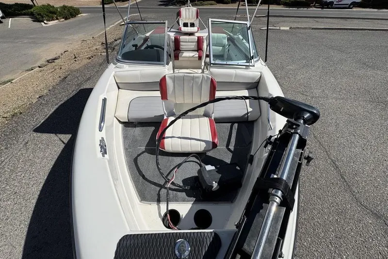 Slide: The Image of 1997 Bayliner Quantum 190 XFS boat with white and red seating, parked on pavement. - 29
