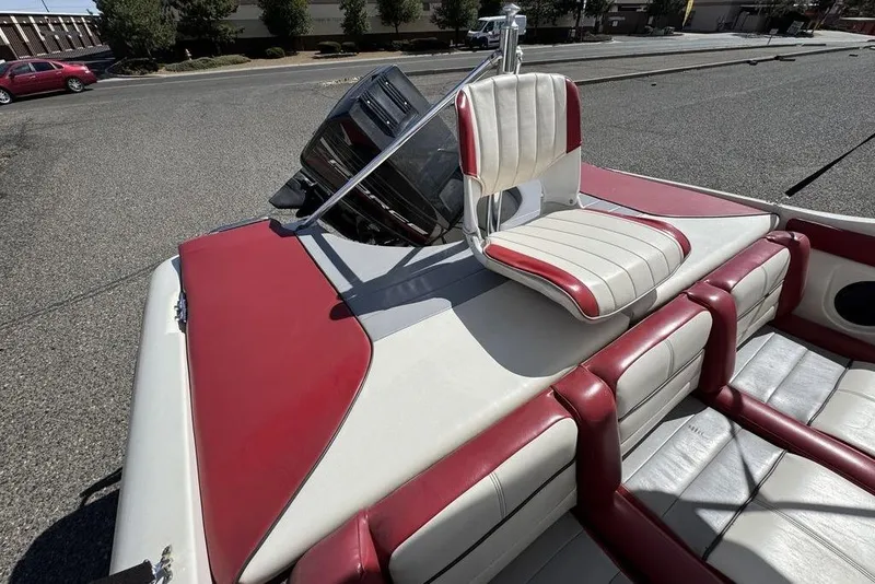 Slide: The Image of 1997 Bayliner Quantum 190 XFS boat with red and white seating, parked on pavement. - 34