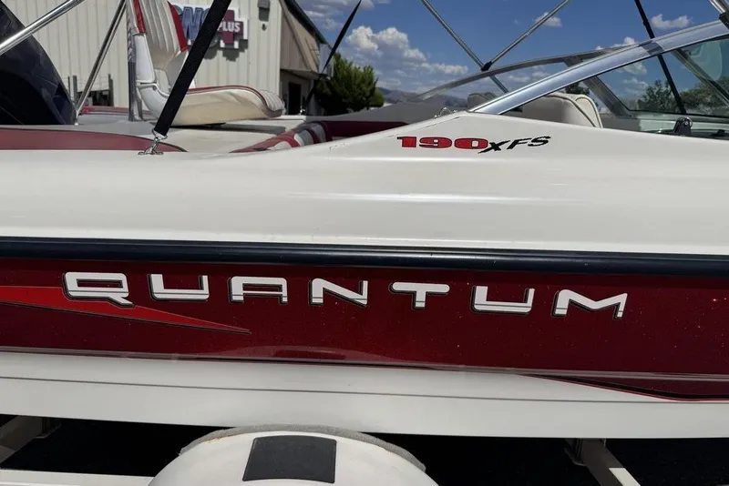 Slide: The Image of 1997 Bayliner Quantum 190 XFS boat with red and white detailing, parked outdoors. - 35