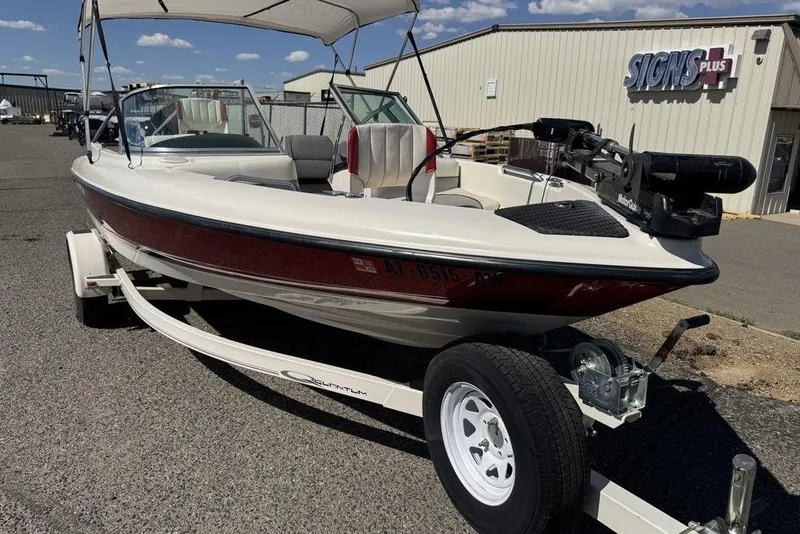 Slide: The Image of 1997 Bayliner Quantum 190 XFS boat on trailer, parked outside a building under a clear sky. - 36