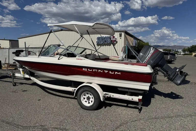 Slide: The Image of 1997 Bayliner Quantum 190 XFS boat with canopy on trailer, parked outdoors. - 46