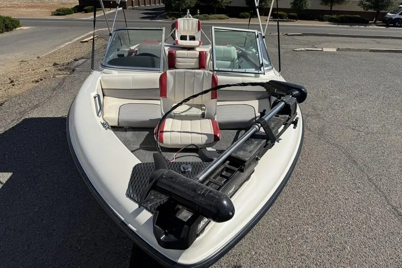 Slide: The Image of 1997 Bayliner Quantum 190 XFS boat with red and white seating, parked on pavement. - 8