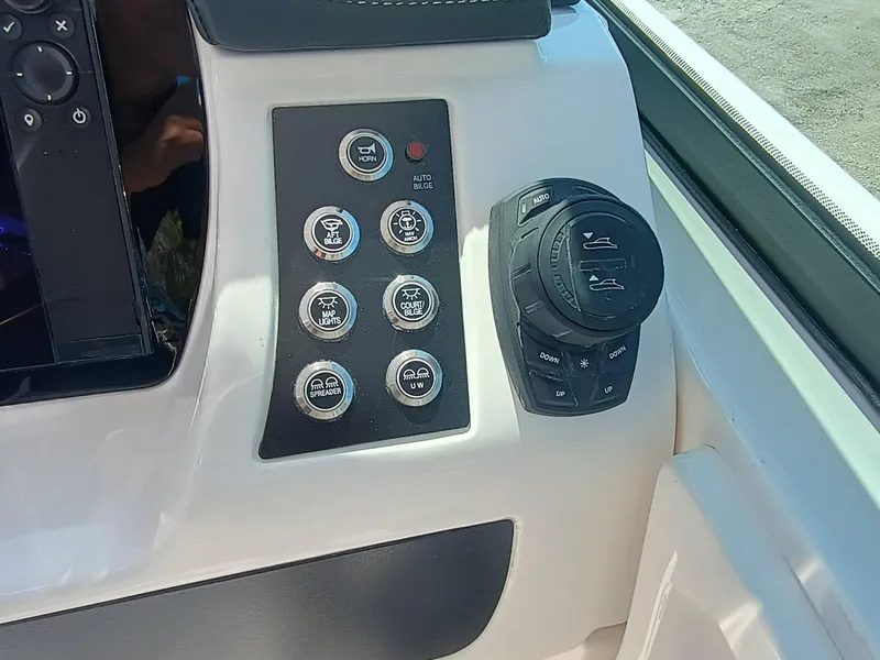 Slide: The Image of Control panel of 2025 Robalo R257 Dual Console boat with various switches and dials. - 14