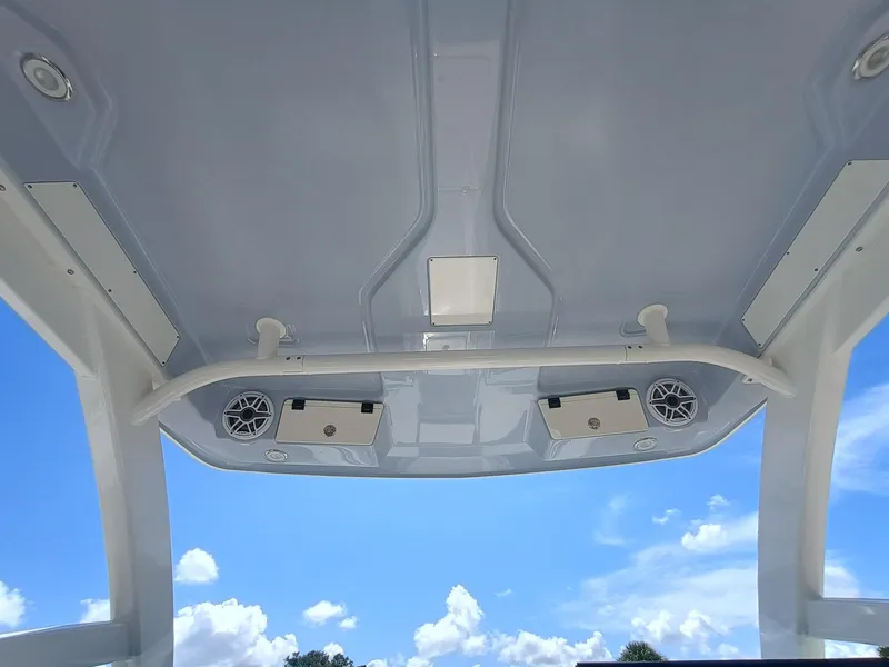 Slide: The Image of 2025 Robalo R257 Dual Console boat roof with speakers against blue sky. - 16
