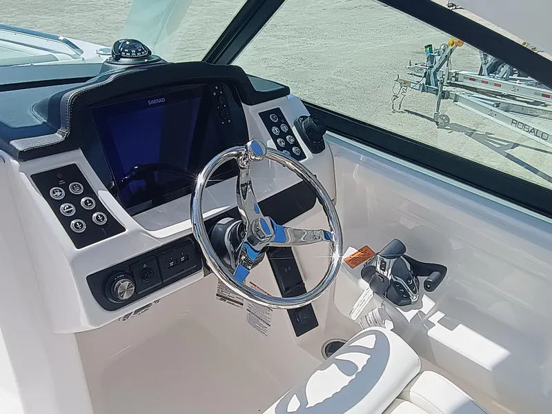 Slide: The Image of 2025 Robalo R257 Dual Console boat dashboard with steering wheel and controls. - 20